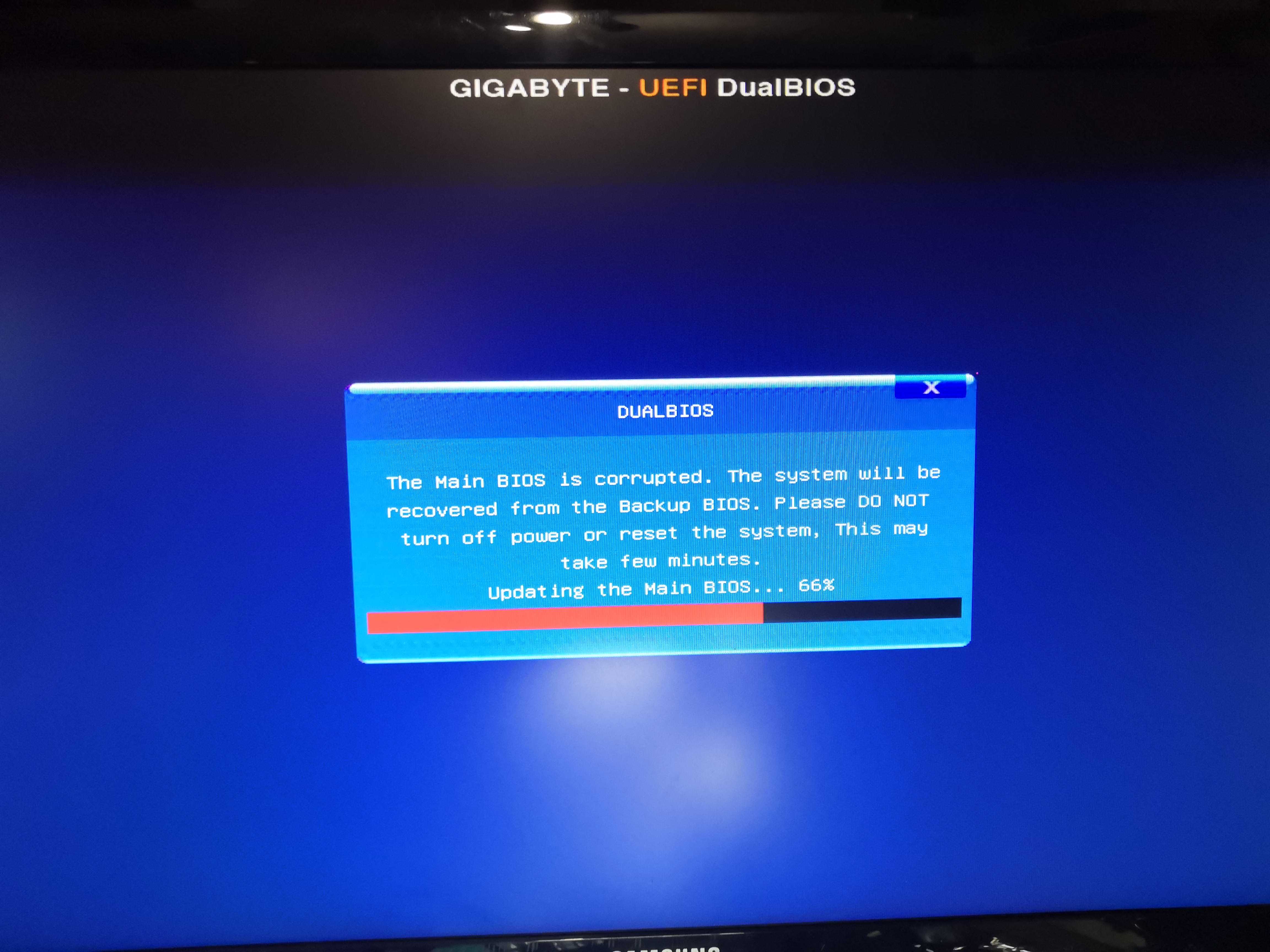 Écran DualBIOS recovery — &ldquo;Updating the Main BIOS&hellip; 66%&rdquo;